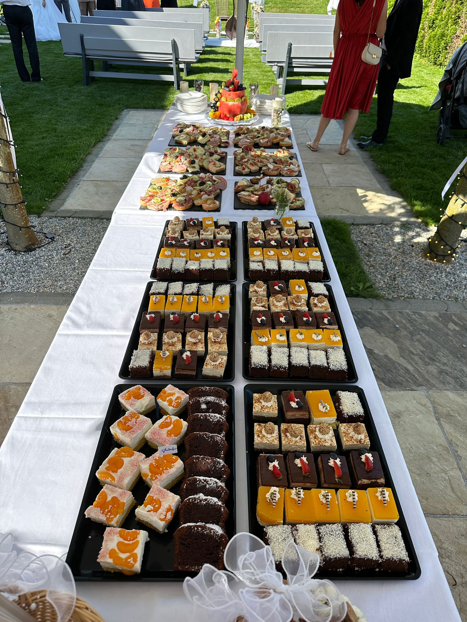 Langes Dessert- und Jausenbuffet mit Brötchen und Mehlspeisen bei einer Feier.